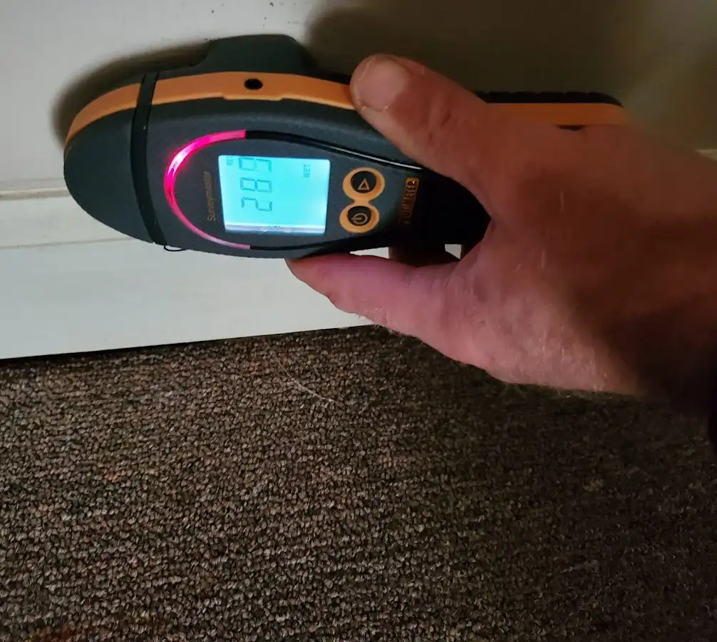 Moisture detection at baseboard during Storm Damage Restoration in Conroe